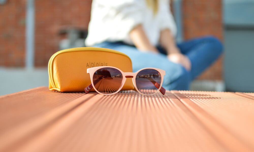 girl sitting next to sunglasses