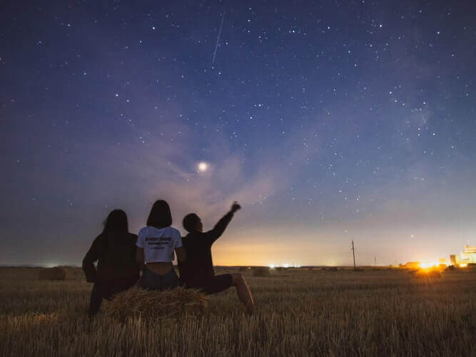 People looking up at the sky during the night
