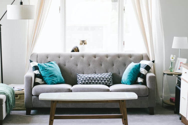 A grey sofa with blue pillows