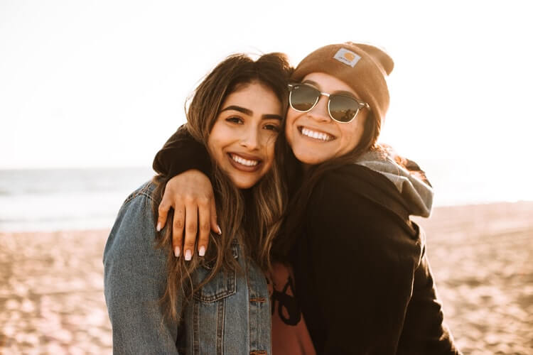 Two friends hugging and smiling