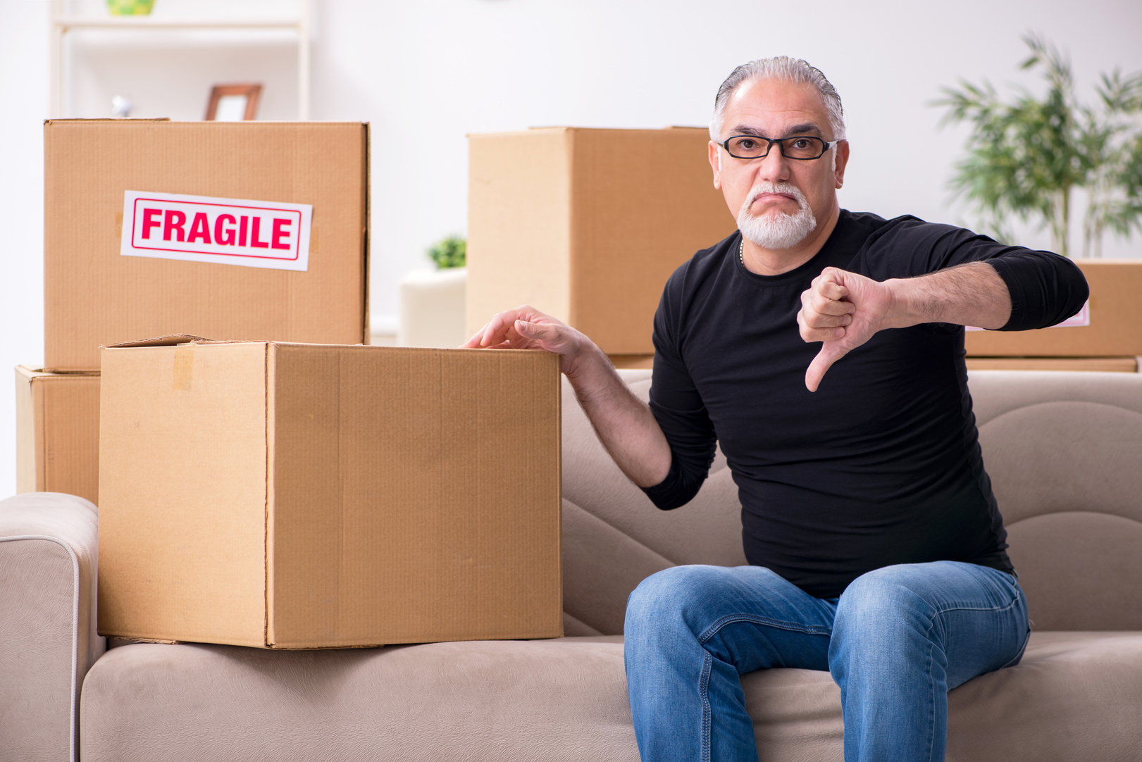 Man surrounded by boxes gives the thumbs down