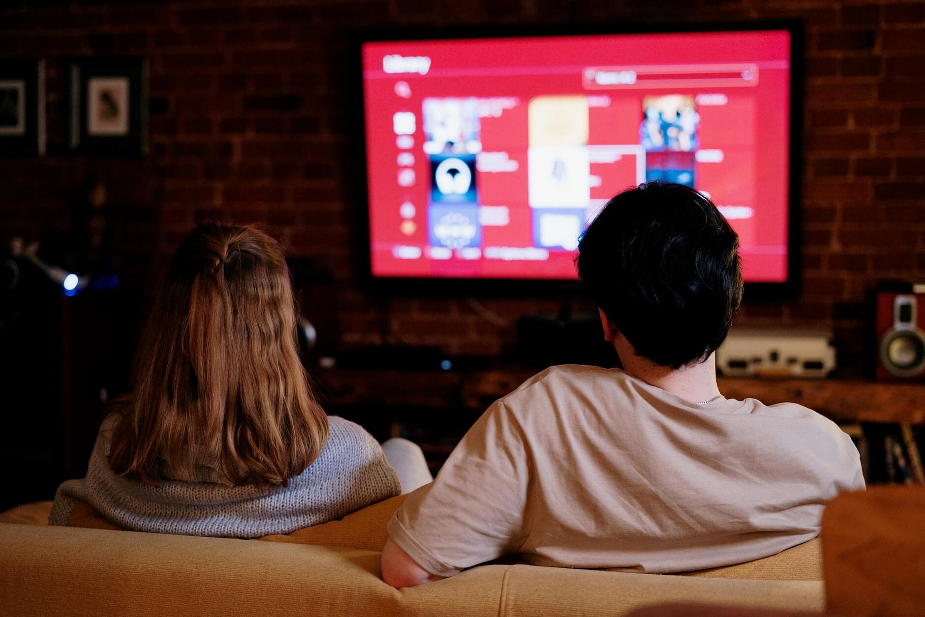 Man and woman are watching TV in the living room after long-distance moving
