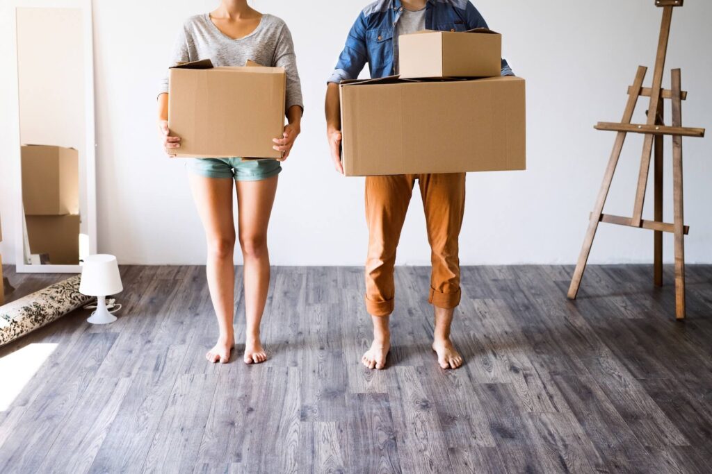 Couple holding boxes while packing for cross-country moving