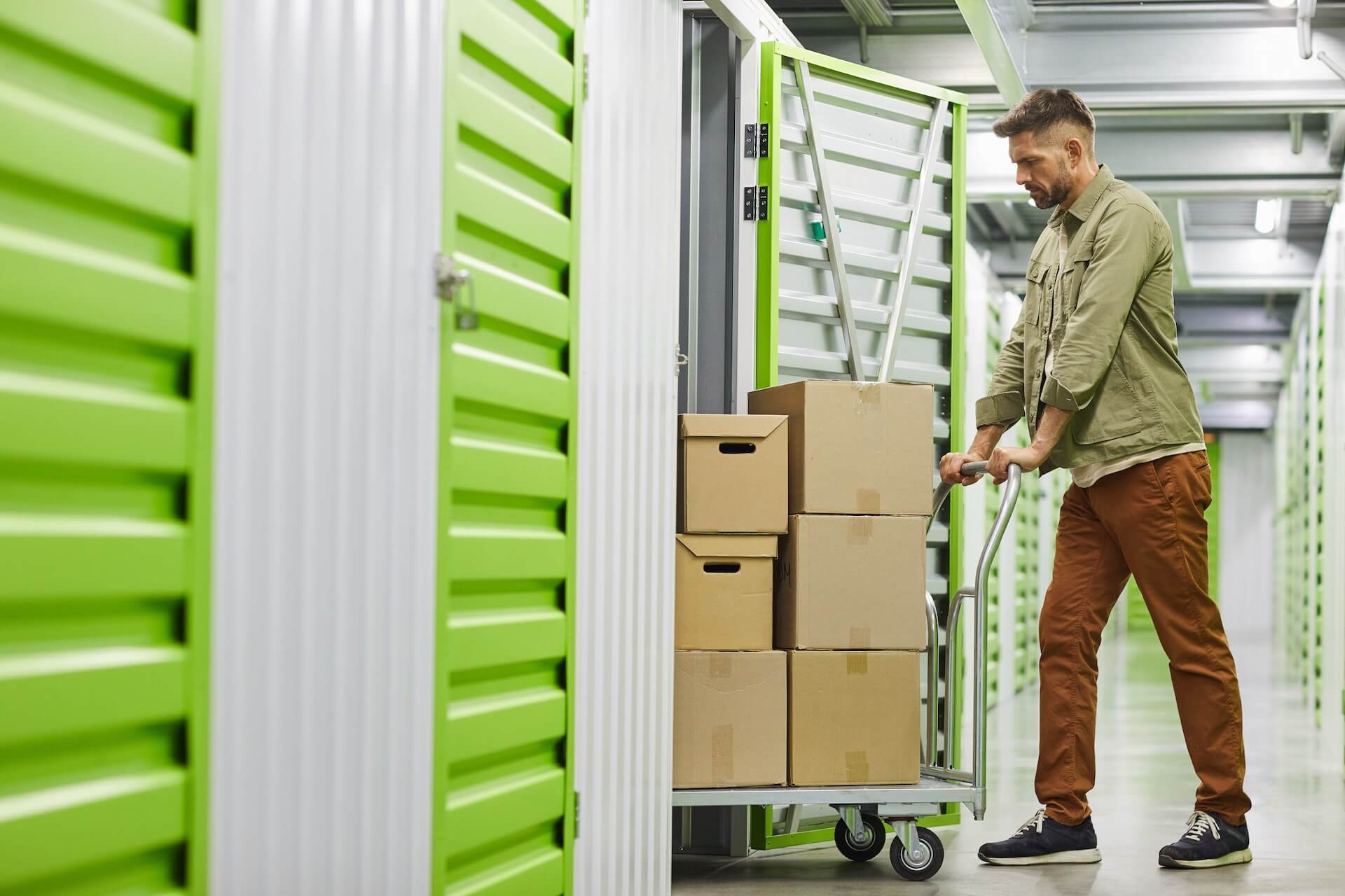 A man moving boxes into a storage unit