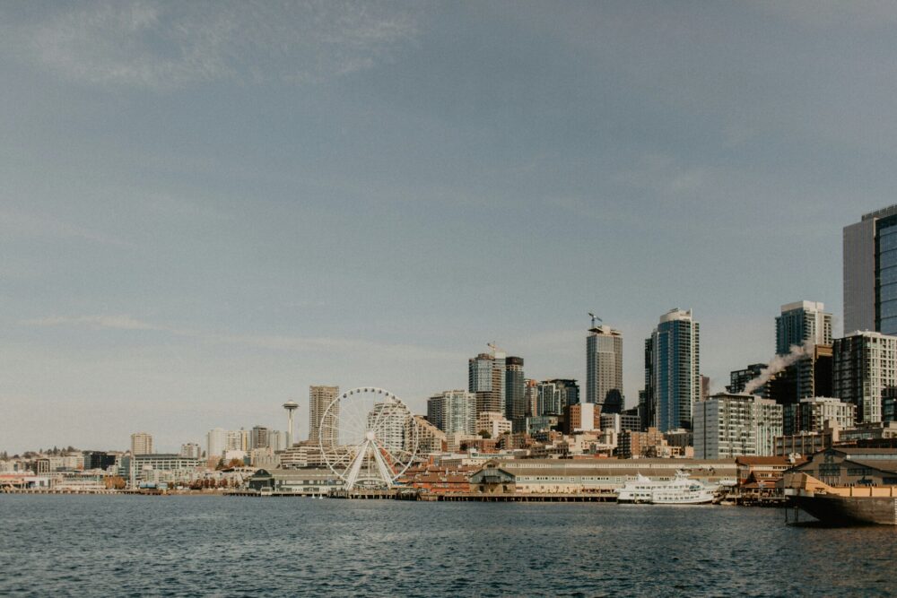 A view of the modern downtown Seattle skyline and a white bridge across the water.