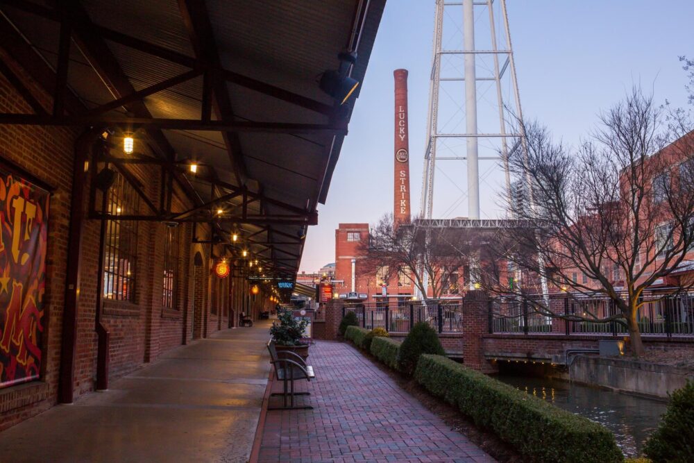 A brick walkway beside a building with a water tower in the background.