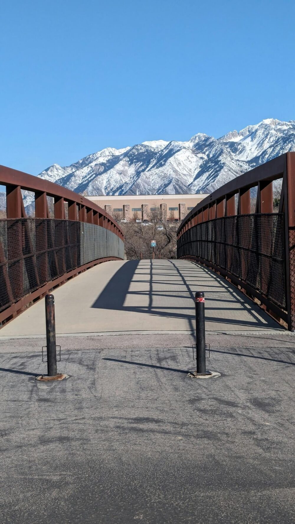 Bridge spanning across scenic landscape with mountains towering in the background.